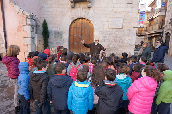 L'alcalde, Josep Maria Rufí, explicant a un grup d’alumnes els orígens de l’Ajuntament de Torroella de Montgrí, davant de la Capella de Sant Antoni, seu de l'antiga Universitat de Torroella, embrió de l’actual corporació local.