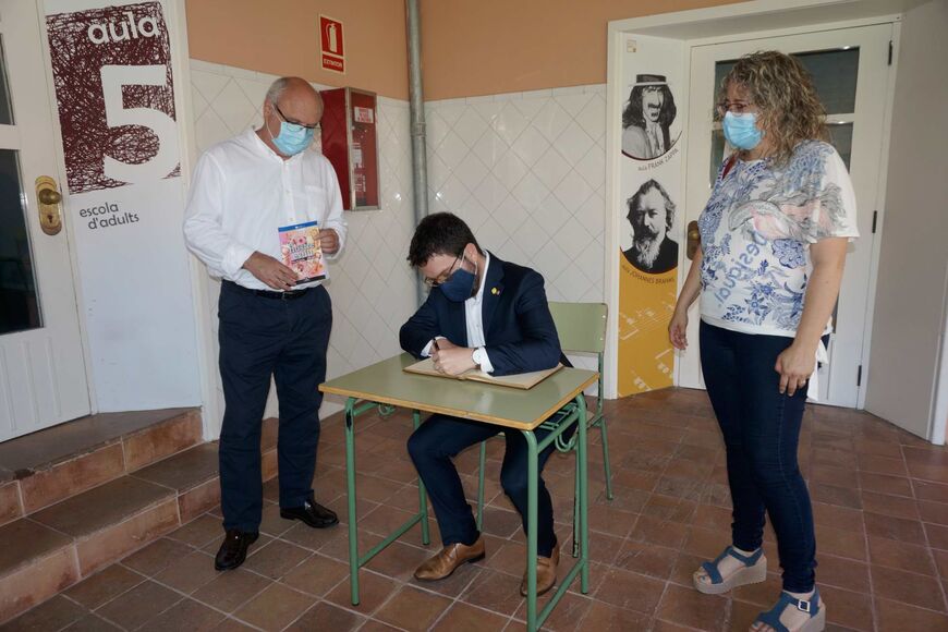El vicepresident, Pere Aragonès, entre l'alcalde, Jordi Colomí i la regidora Anna Company, durant la signatura en el Llibre d'Honor de l'Ajuntament.